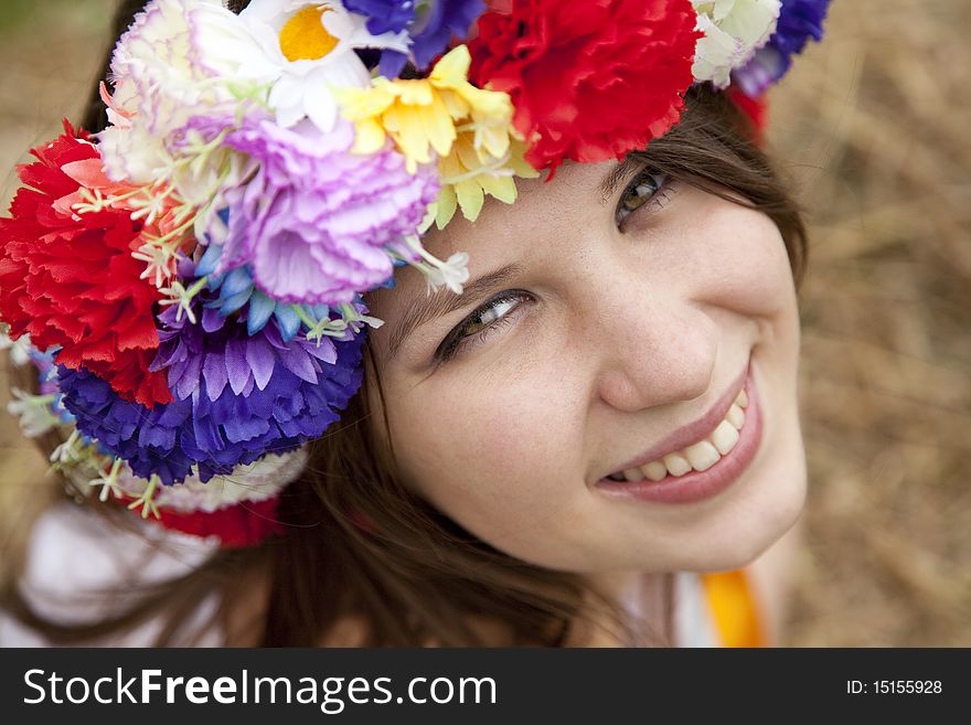 Slav girl with wreath at field. Outdoor shot.