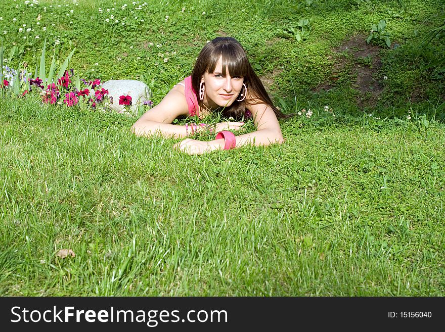 Girl posing outdoor lying on a meadow