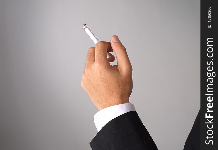 Businessman in coat holding a cigarette. Businessman in coat holding a cigarette