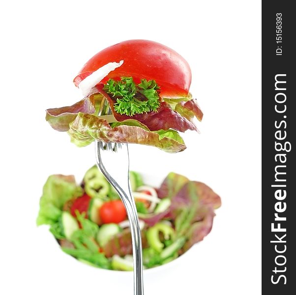 Fork with vegetable salad and salad in a bowl isolated on white. Fork with vegetable salad and salad in a bowl isolated on white