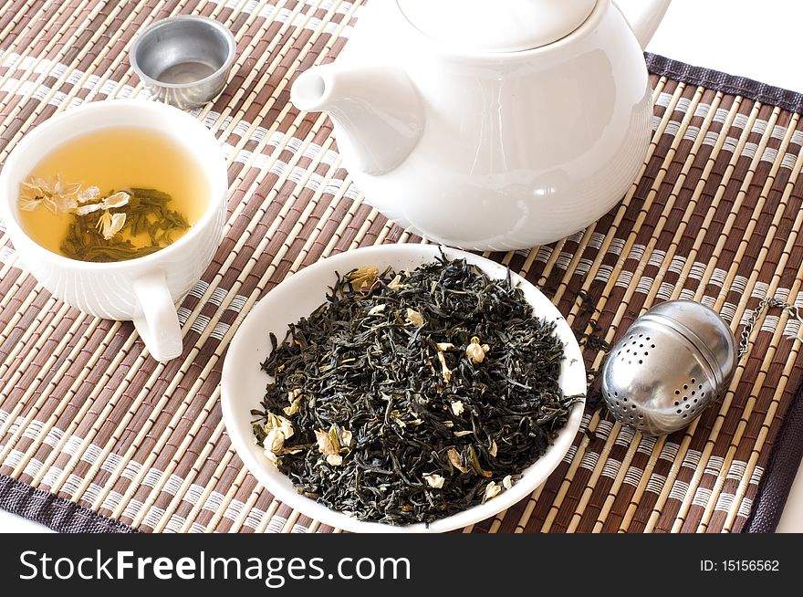 White cup with tea on a white background, alongside dry tea