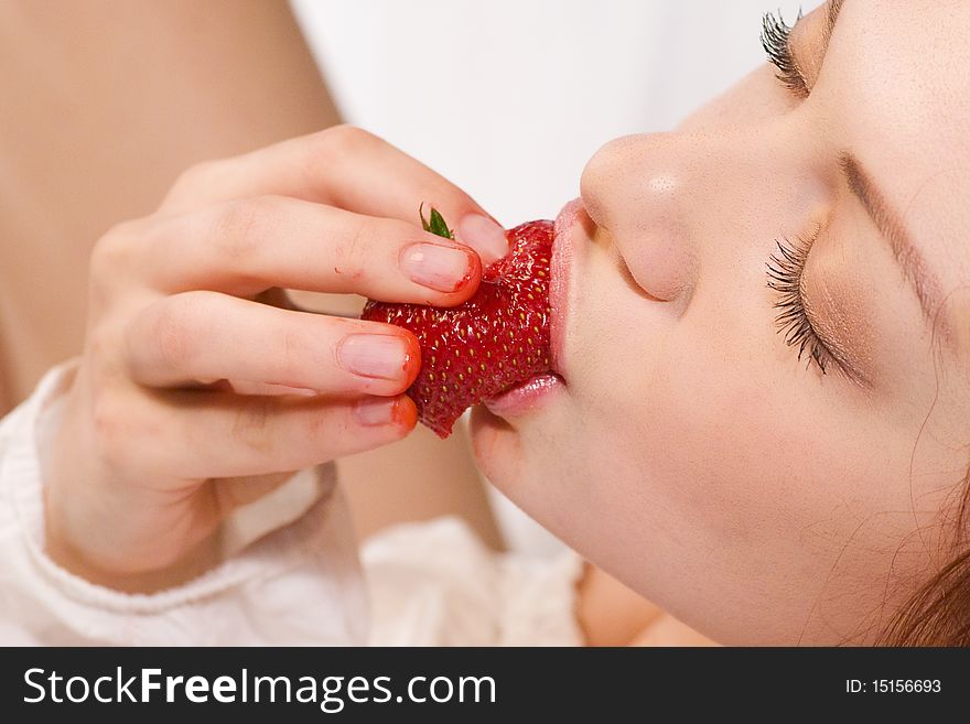 Beautiful woman eating a strawberry. Beautiful woman eating a strawberry