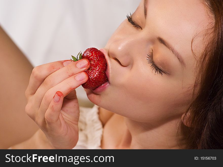 Beautiful woman eating a strawberry. Beautiful woman eating a strawberry