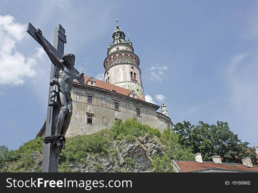 Jesus on a crucifix and a chateau tower in cesky krumlov in czech republic