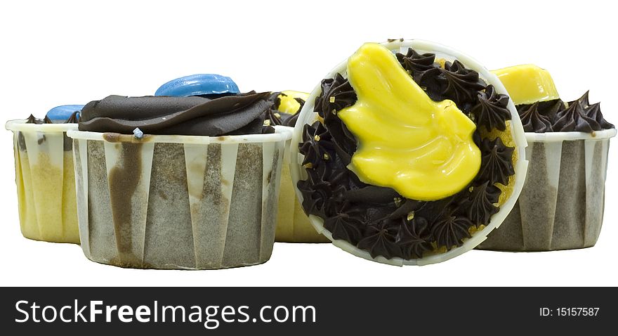 Several cupcake with yellow, blue and chocolate topping, one facing camera, and the rest facing upwards
