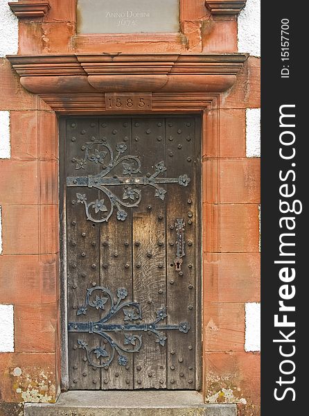 An image of an ancient , decorated, studded,  wooden door of an old church dated 1585. An image of an ancient , decorated, studded,  wooden door of an old church dated 1585.