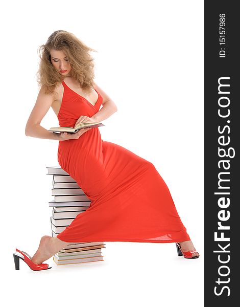 Young woman with book sits on books isolated in white