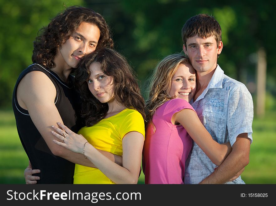 Four Young People Embrace And Stand