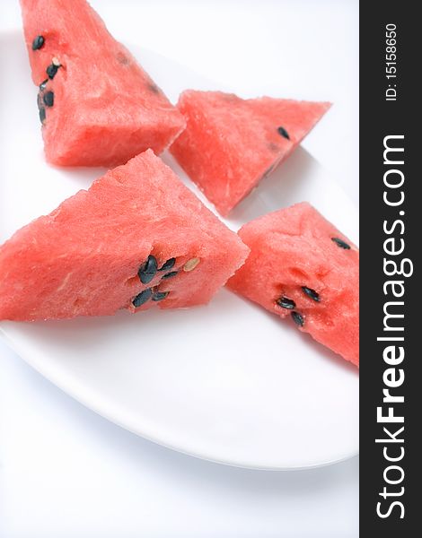 Slices of watermelon portion in plate close up isolated over white bacground