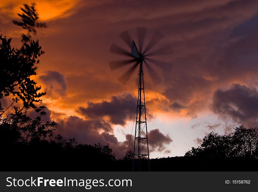 Windmill in a storm threatening sunset