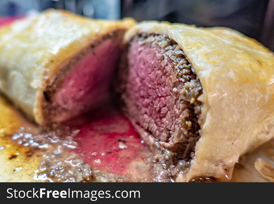 Beef wellington cut in half and ready to be  carved