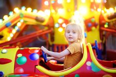 Little Boy Having Fun On Attraction In Public Park. Child Riding On A Merry Go Round At Summer Evening. Attraction, Planes, Cars, Royalty Free Stock Photos