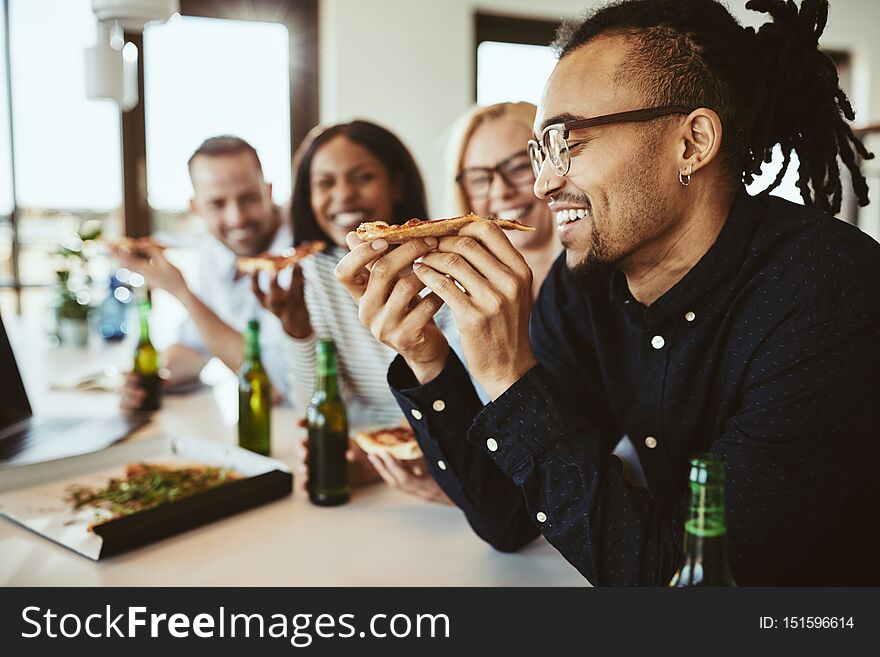 Laughing African American businessman having beers and pizza wit