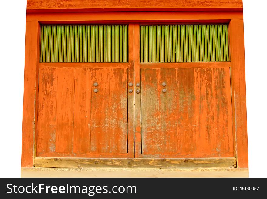 A large, worn, orange and green gate to a Japanese temple. A large, worn, orange and green gate to a Japanese temple