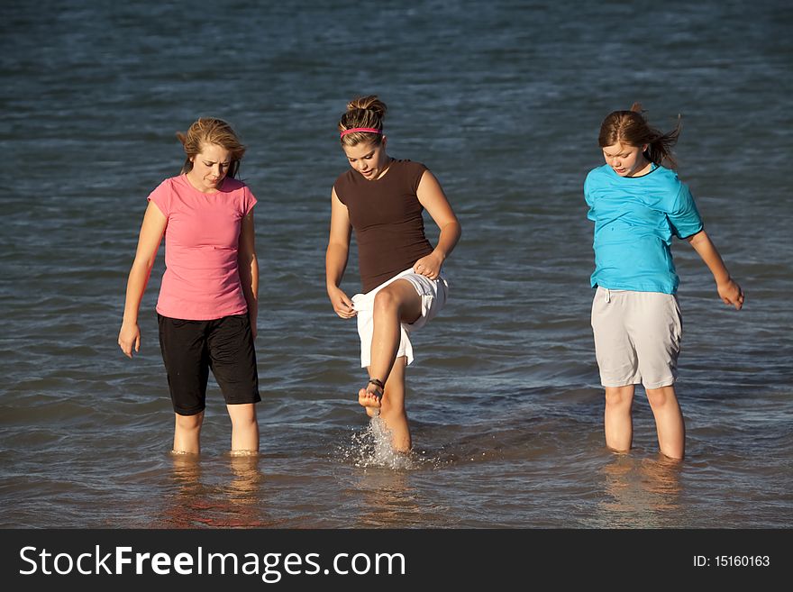 Some teenage girls in the outdoors playing in the water and splashing. Some teenage girls in the outdoors playing in the water and splashing.