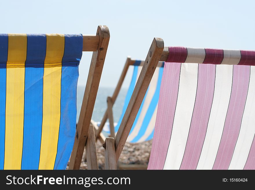 Summer deckchairs against a hazy sky with sea in the distance. Summer deckchairs against a hazy sky with sea in the distance