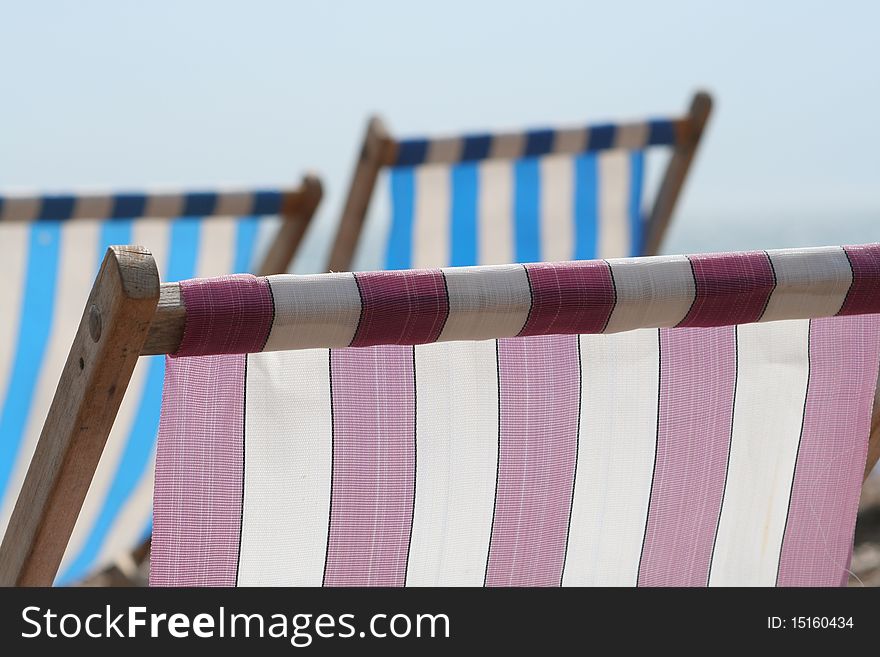 Summer deckchairs against a hazy sky with sea in the distance. Summer deckchairs against a hazy sky with sea in the distance