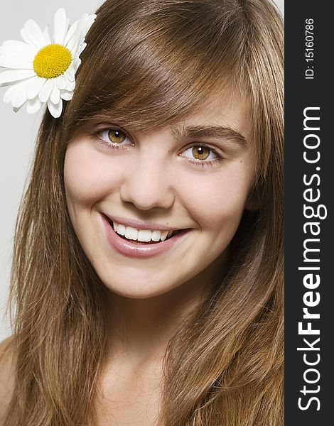 Portrait of fresh and beautiful woman with camomile