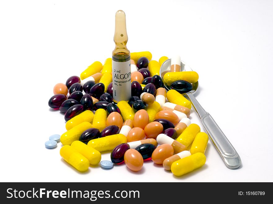 Colorful pills, tablets, vial and spoon on isolated white. Colorful pills, tablets, vial and spoon on isolated white