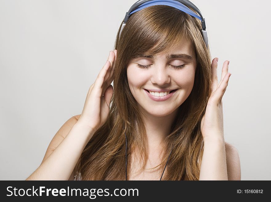 Closeup of a smiling young woman listening music