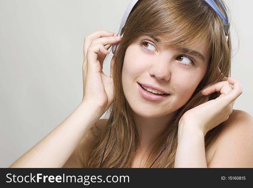 Closeup of a smiling young woman listening music