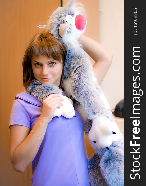 A girl holds a gray toy-kitten. A girl holds a gray toy-kitten