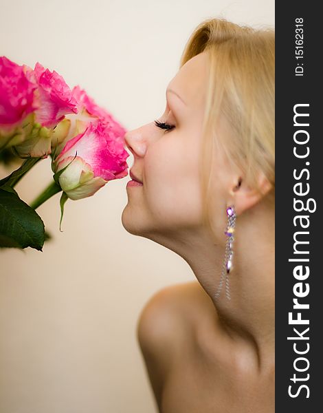 Girl sniffing beautiful flower - pink roses. Girl sniffing beautiful flower - pink roses