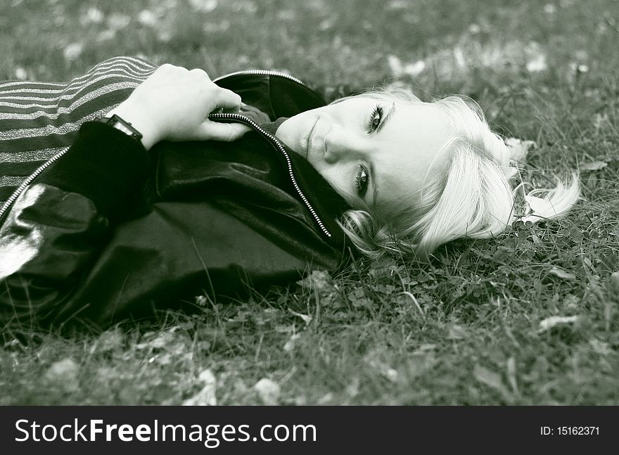 A young woman is lying in grass