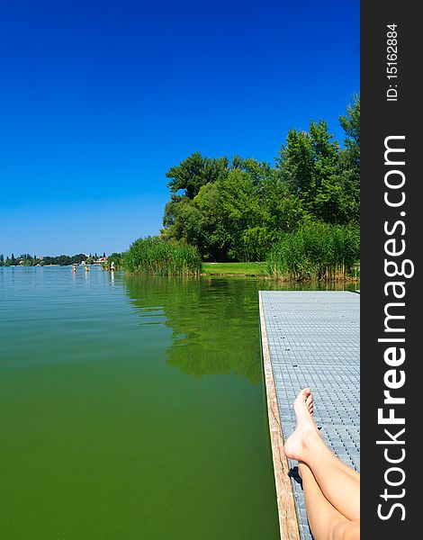 Legs over the green lake in Tata