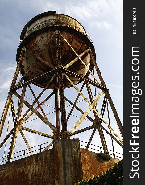 A foreboding marker of the Alcatraz Prison grounds. The massive weathered water tank stands tall with shimmering rust stains in the afternoon sun. A foreboding marker of the Alcatraz Prison grounds. The massive weathered water tank stands tall with shimmering rust stains in the afternoon sun.