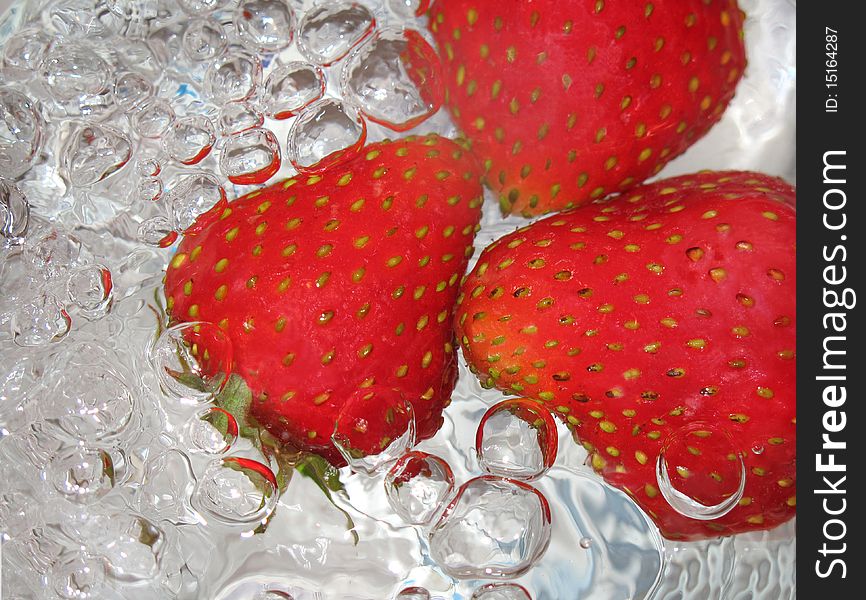 A fresh strawberry in water bubbles