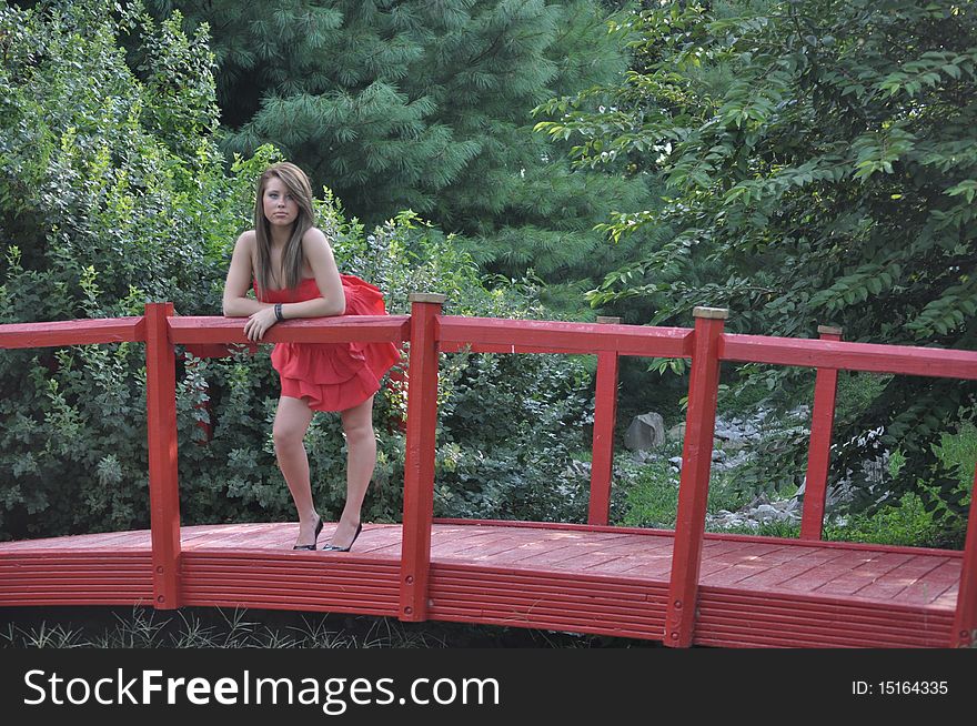 Lady in red standing on a red bridge. Lady in red standing on a red bridge