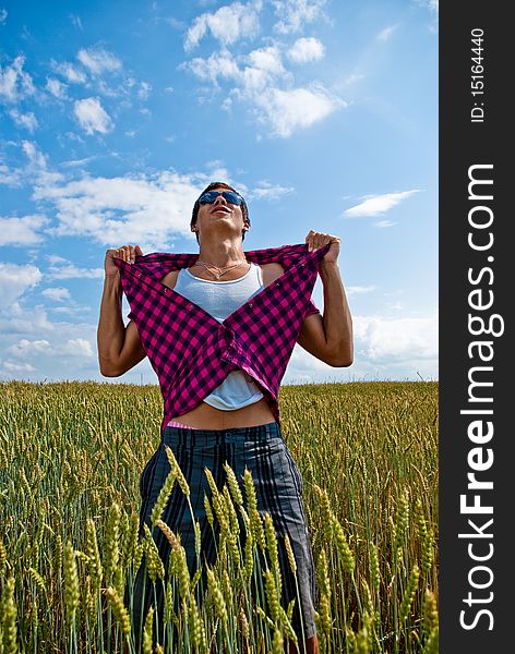 Strong young man display the power of sun, wheat, nutrition and healthy lifestyle. Tearing his shirt. Strong young man display the power of sun, wheat, nutrition and healthy lifestyle. Tearing his shirt.