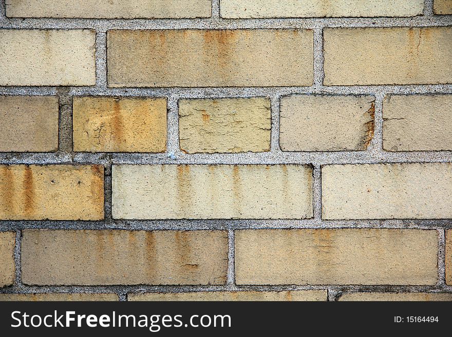 A yellow brick wall with mortar between the bricks. A yellow brick wall with mortar between the bricks.