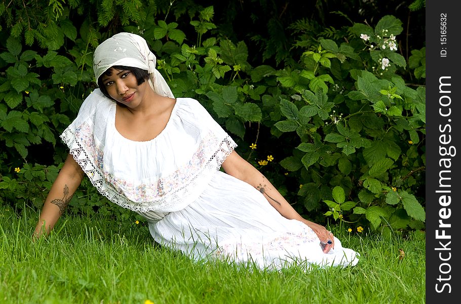 Beautiful black woman wearing scarf on head in nature setting. Beautiful black woman wearing scarf on head in nature setting