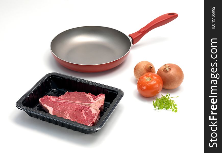 A T Bone steak in a plastic supermarket tray isolated against a white background. A T Bone steak in a plastic supermarket tray isolated against a white background