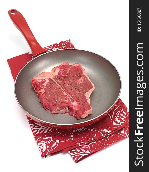 A T Bone steak in a frying pan isolated against a white background. A T Bone steak in a frying pan isolated against a white background