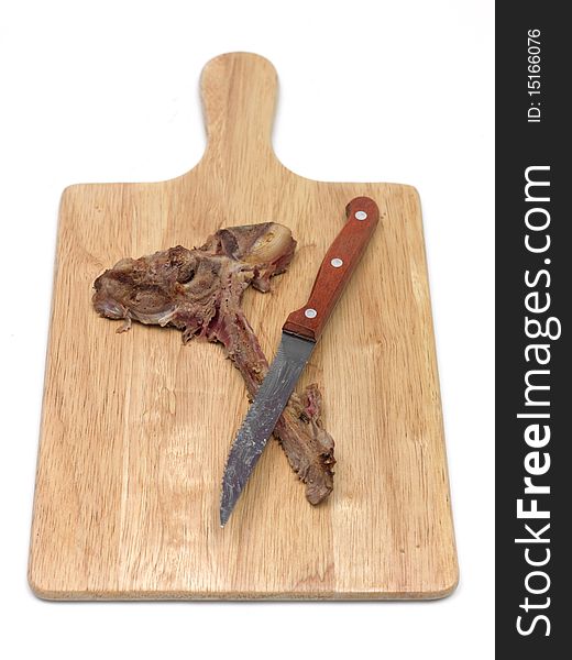 A T Bone steak on a cutting board isolated against a white background