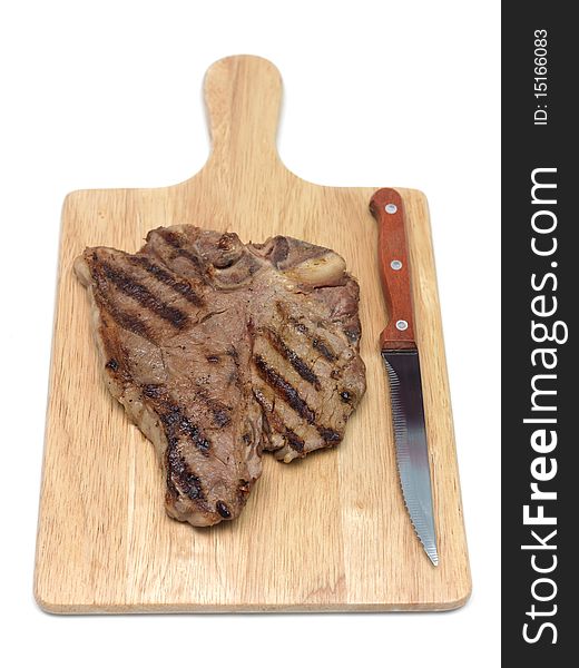 A T Bone steak on a cutting board isolated against a white background