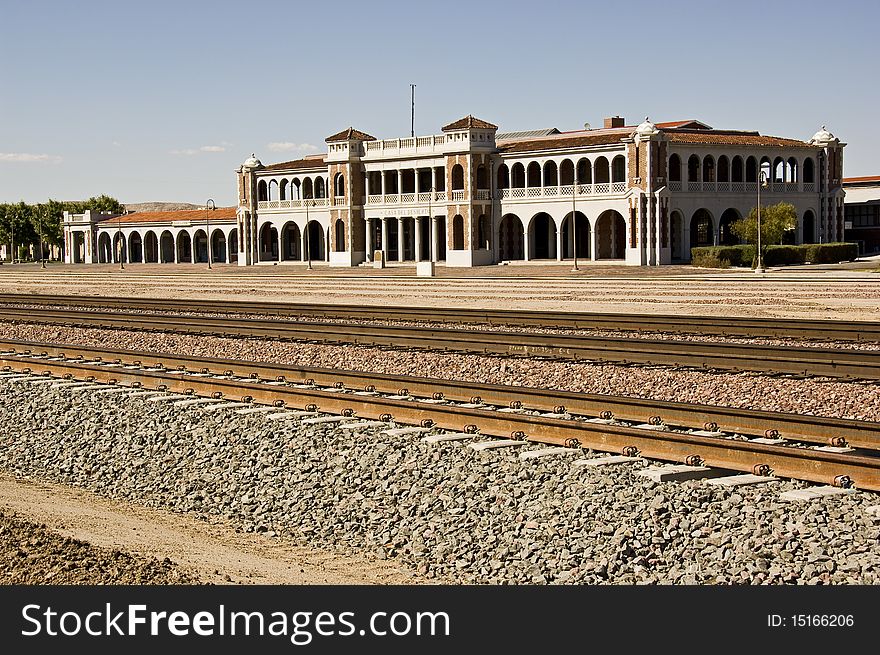 The tracks in front of the recently remodeled Barstow Railroad Station in Barstow, California showing some tank cars and other traffic in the area. The tracks in front of the recently remodeled Barstow Railroad Station in Barstow, California showing some tank cars and other traffic in the area