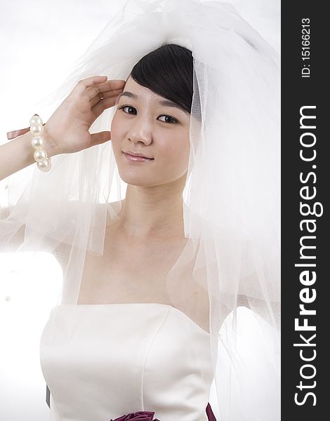 Beautiful bride with perfect natural makeup,smiling,wearing mantilla,pearls round wrist