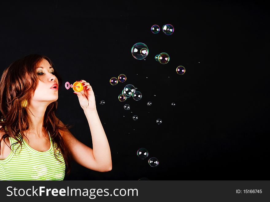 Picture of a young modest beautiful girl lets soap balls on back background