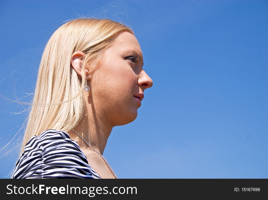Blond girl posing in nature with sky in background