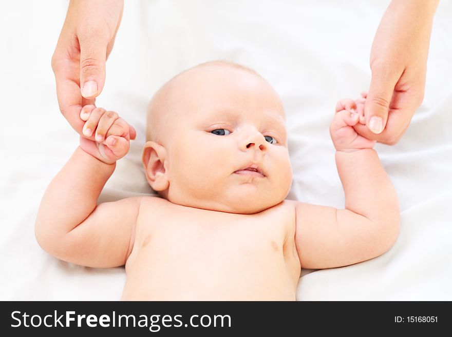 The parent holds for hands of the baby. Age - 3 months