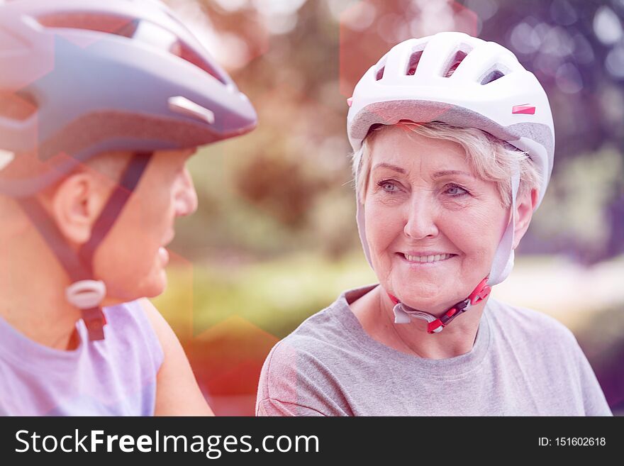 Active senior women wearing cycling helmet while looking at man. Active senior women wearing cycling helmet while looking at man