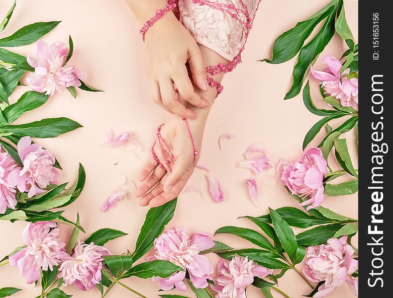 hands of a young girl with smooth skin and a bouquet of peonies
