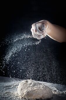 Chef Prepares The Dough With Flour. Male Sprinkling Flour Over Dough On Table On Dark Background. Vertical. Copy Space. Conceptn Royalty Free Stock Photography