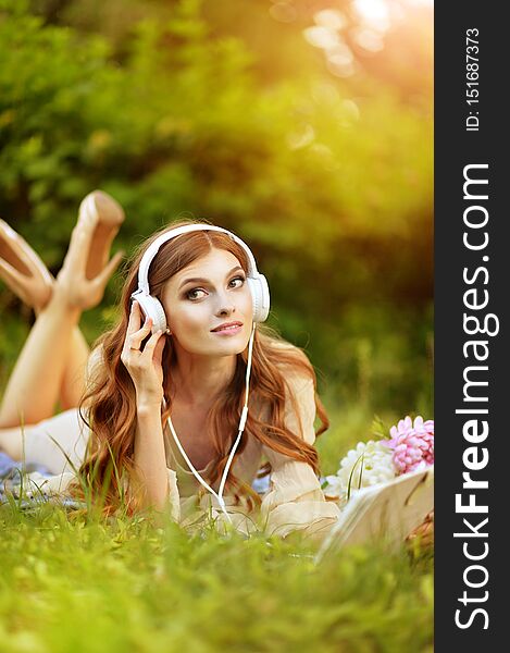 Portrait Of Beautiful Young Woman Lying On Green Meadow