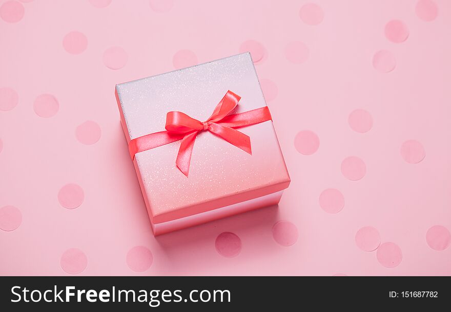 Pink present box on pink konfetti background