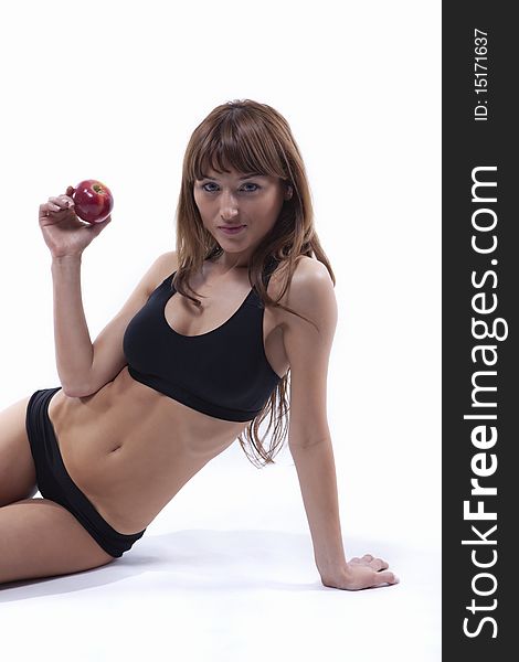 Young beautiful muscle woman with apple